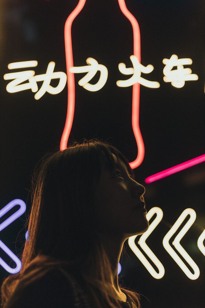 Silhouet van een vrouw voor neonlicht bij nacht