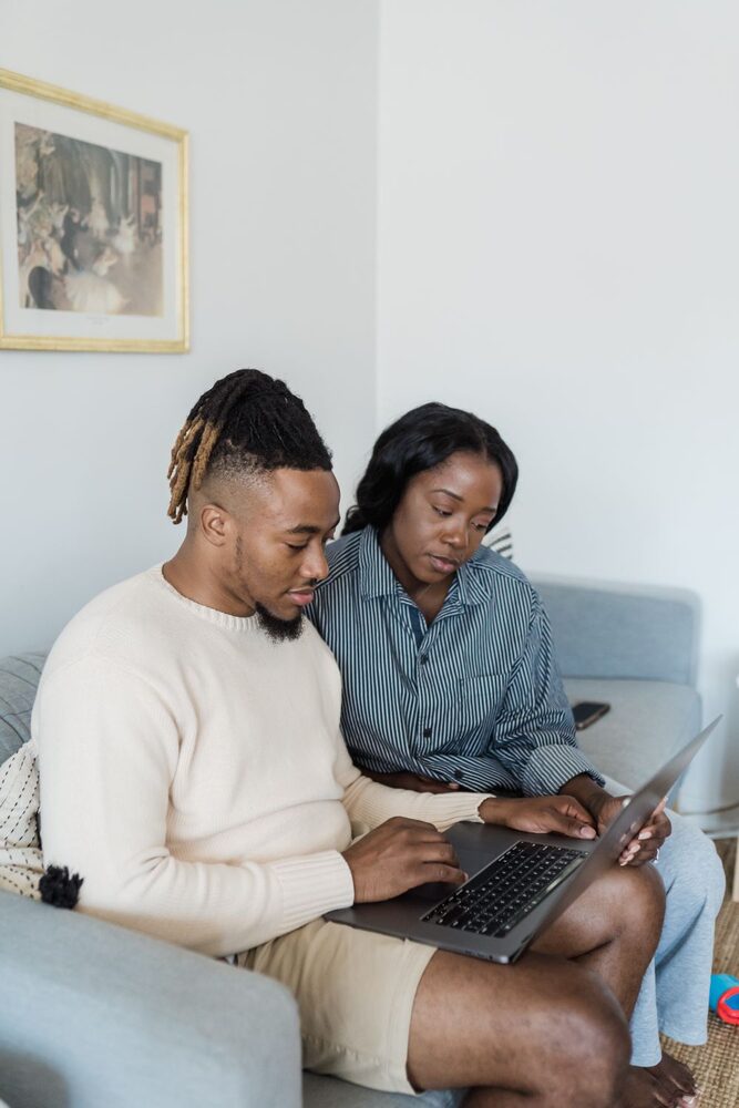 Lachend stel op de bank kijkt samen naar een laptop