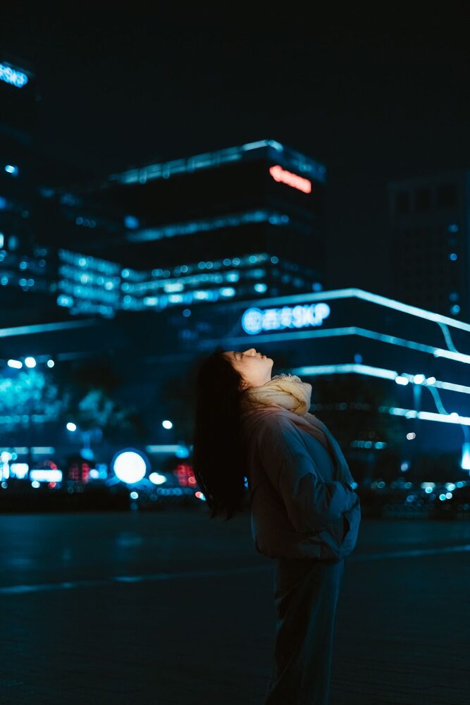 Dona en una ciutat il·luminada amb neons blaus de nit